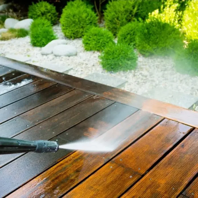 nettoyage haute pression Nettoyage d'un patio en bois avec un nettoyeur haute pression. Verdure en arrière-plan.